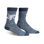 Pair of crew socks in blue and white. Design features an astronaut riding a whale amidst stars and sparkles.