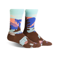 Brown crew socks with a pastel Glacier National Park scene. Features mountains, trees, and camping icons.