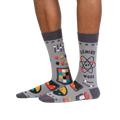 Lifestyle shot of a person wearing a pair of gray 'Genius at Work' socks, showcasing how they look on the feet.