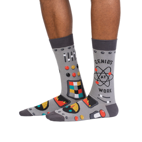 Lifestyle shot of a person wearing a pair of gray 'Genius at Work' socks, showcasing how they look on the feet.