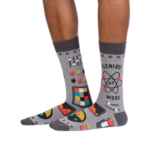 Lifestyle shot of a person wearing a pair of gray 'Genius at Work' socks, showcasing how they look on the feet.