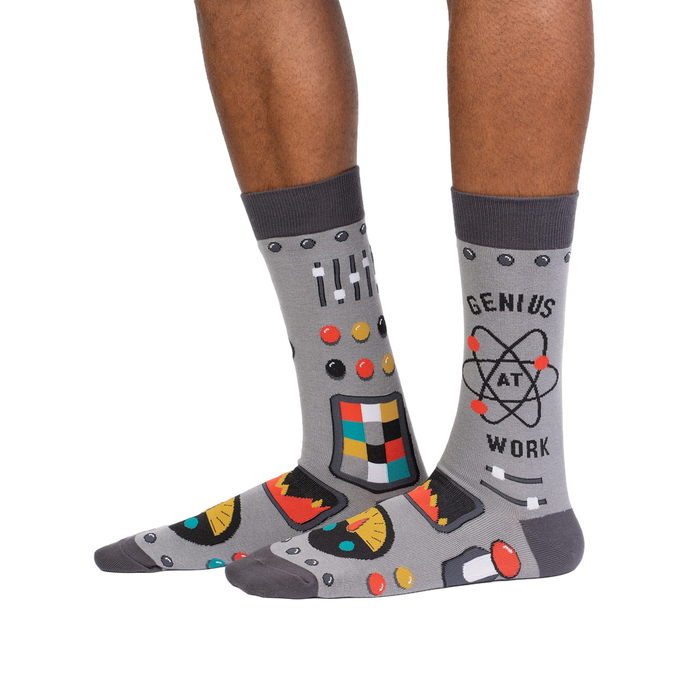 Lifestyle shot of a person wearing a pair of gray 'Genius at Work' socks, showcasing how they look on the feet.