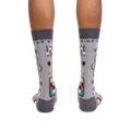 Rear view of a pair of gray 'Genius at Work' socks, showing the full design on the back of each sock.