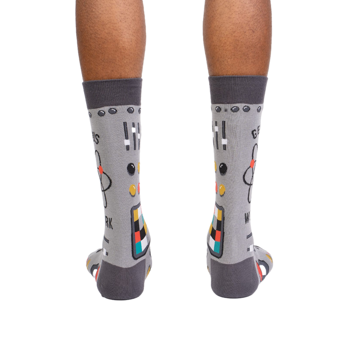 Rear view of a pair of gray 'Genius at Work' socks, showing the full design on the back of each sock.