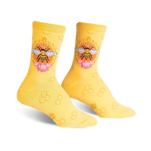 A pair of women's crew socks in yellow with a repeating honeycomb pattern.  A central design shows a bee in an ornate frame with pink flowers.