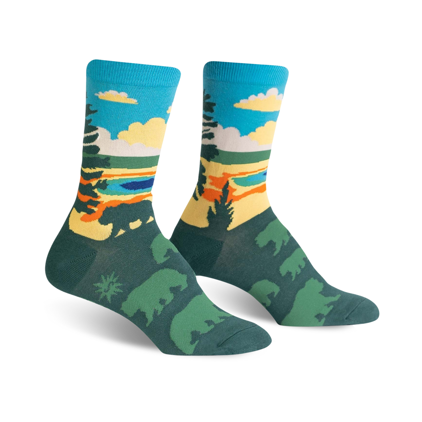 A pair of crew socks with a scenic nature design. The socks are teal, green, yellow, and orange, depicting a landscape with bears.