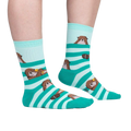 Lifestyle shot of a person wearing the teal and mint otter socks. Shows the fit and look on feet.