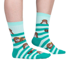 Lifestyle shot of a person wearing the teal and mint otter socks. Shows the fit and look on feet.