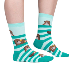 Lifestyle shot of a person wearing the teal and mint otter socks. Shows the fit and look on feet.