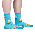 Lifestyle shot showing the socks on a person's feet; teal crew socks with white cats on donut floats.
