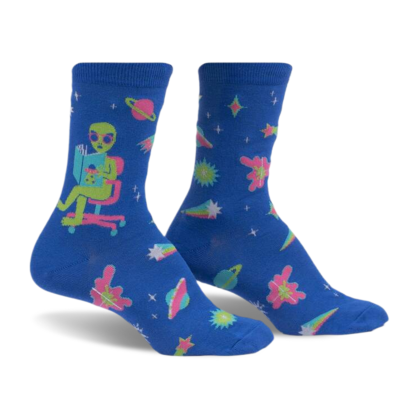 Crew socks in blue with an alien reading a book, planets, stars, and comets. Pink, teal, and green accents. Glow-in-the-dark.