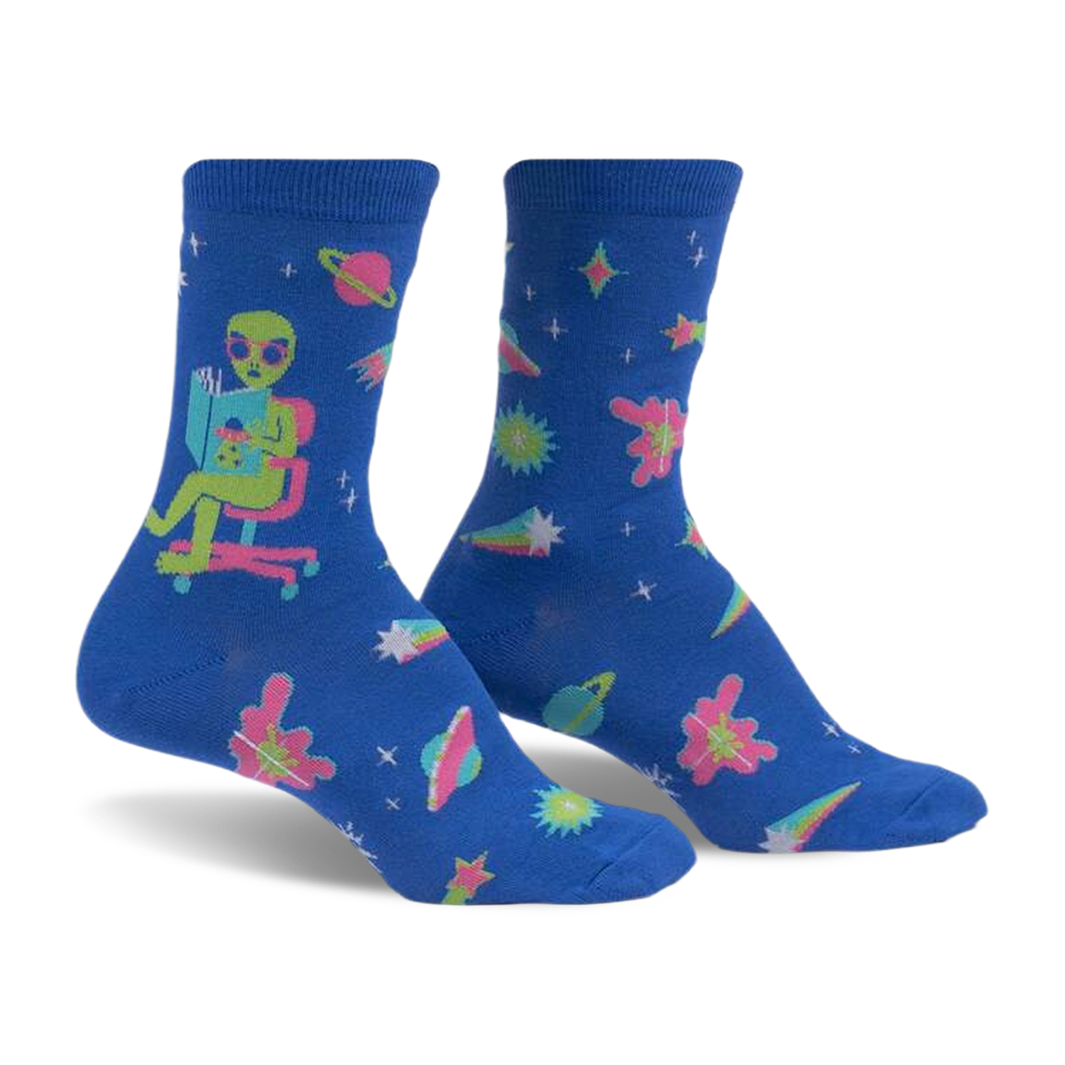 Crew socks in blue with an alien reading a book, planets, stars, and comets. Pink, teal, and green accents. Glow-in-the-dark.
