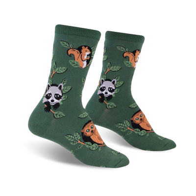 woodland watchers crew socks featuring a pattern of raccoons, owls, and squirrels climbing on branches with green leaves.  