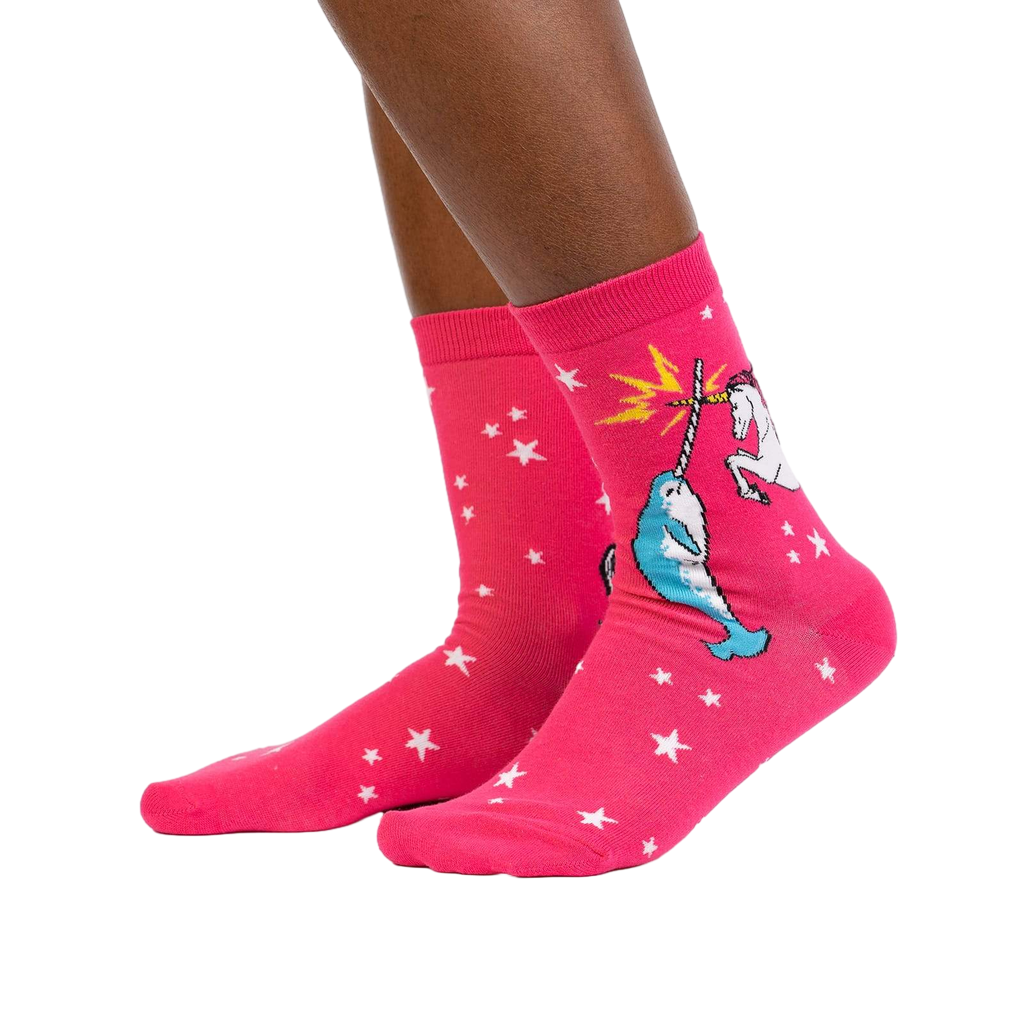 Lifestyle shot showing the socks on a person's legs. They're pink with a unicorn and narwhal graphic.
