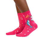 Lifestyle shot showing the socks on a person's legs. They're pink with a unicorn and narwhal graphic.