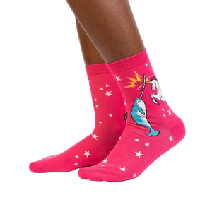 Lifestyle shot showing the socks on a person's legs. They're pink with a unicorn and narwhal graphic.