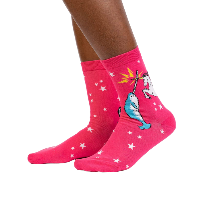 Lifestyle shot showing the socks on a person's legs. They're pink with a unicorn and narwhal graphic.