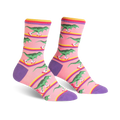 Crew socks in pink, purple, and yellow, featuring a pattern of green dinosaurs roller-skating.