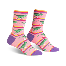 pink womens crew socks with a design of green roller-skating dinosaurs on a rainbow-colored stripe.  