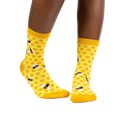 Lifestyle shot of a model wearing the yellow honeycomb bee socks.