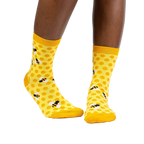 Lifestyle shot of a model wearing the yellow honeycomb bee socks.