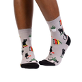 Lifestyle shot of model wearing 'Booked For Meow' socks, showcasing how they look on feet.