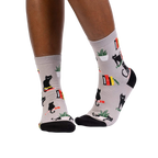 Lifestyle shot of model wearing 'Booked For Meow' socks, showcasing how they look on feet.