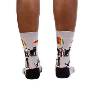 Rear view of model's legs wearing 'Booked For Meow' socks.