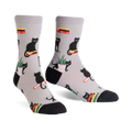 Pair of grey crew socks with a repeating pattern of black cats sitting on books and in potted plants.  Red, yellow, and green accents.