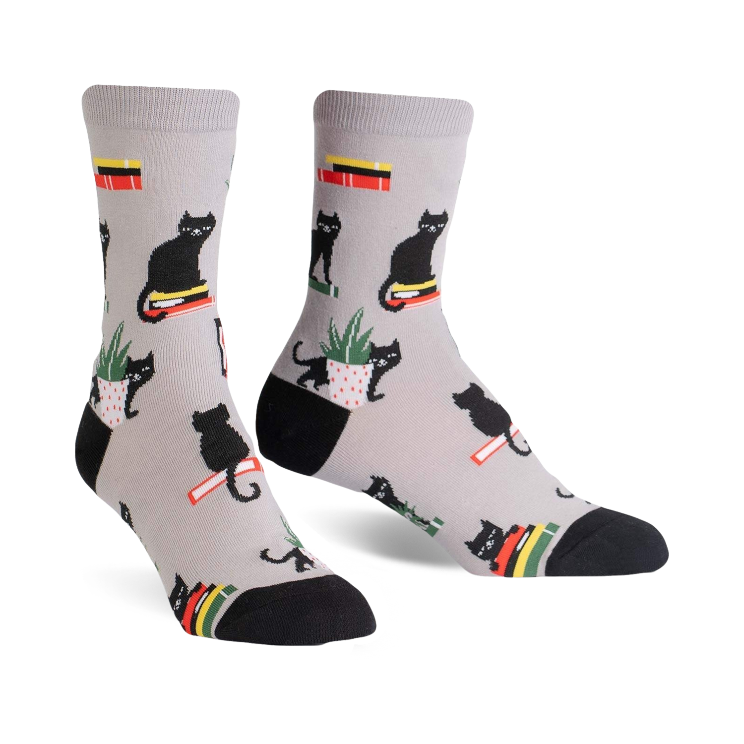 Pair of grey crew socks with a repeating pattern of black cats sitting on books and in potted plants.  Red, yellow, and green accents.