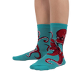Lifestyle shot showing The Octive Reader socks on a person's feet, showcasing the fit and teal color.