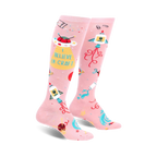 Pair of pink knee-high socks with a fun design featuring rockets, UFOs, crafting icons, and the text 'I Believe In Craft'.