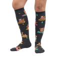 Lifestyle shot showing a person's legs wearing the Red Panda Pose knee-high socks against a white background.