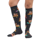 Lifestyle shot showing a person's legs wearing the Red Panda Pose knee-high socks against a white background.