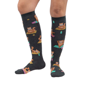 Lifestyle shot showing a person's legs wearing the Red Panda Pose knee-high socks against a white background.