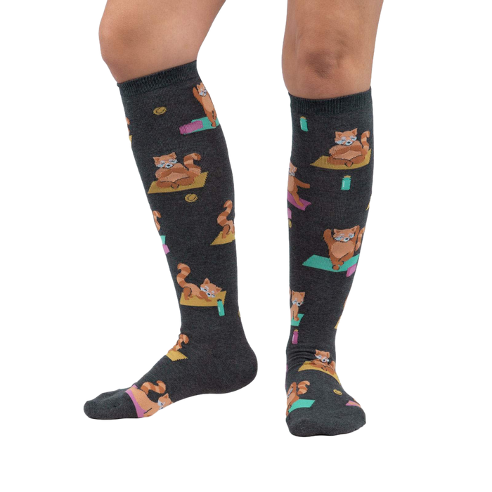 Lifestyle shot showing a person's legs wearing the Red Panda Pose knee-high socks against a white background.