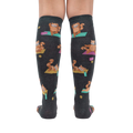 Rear view of a person wearing the Red Panda Pose knee-high socks, highlighting the full design and fit.