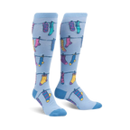 Pair of light blue knee-high socks with a pattern of colorful socks hanging on a clothesline. Fun and whimsical design.