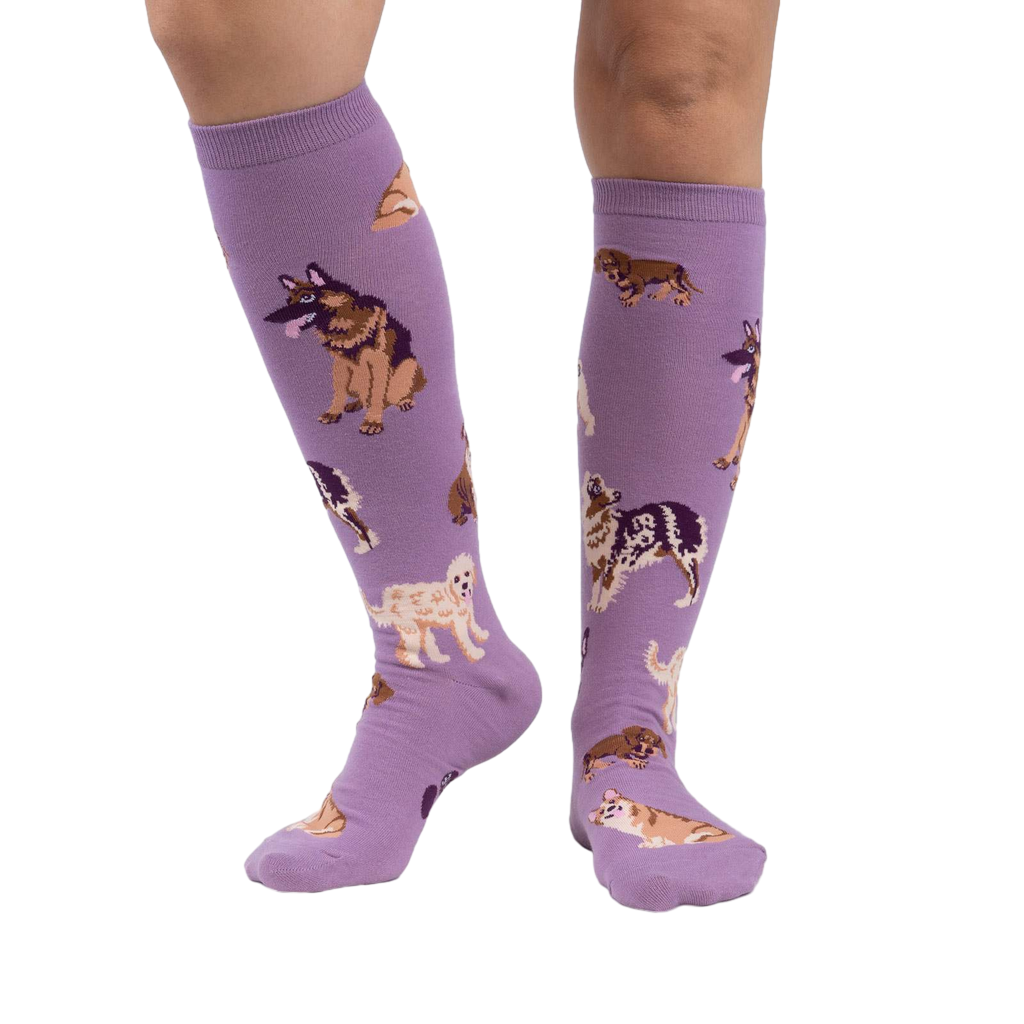 Lifestyle photo showcasing the lavender purple knee-high socks with dog illustrations on a person's legs.