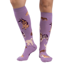 Lifestyle photo showcasing the lavender purple knee-high socks with dog illustrations on a person's legs.