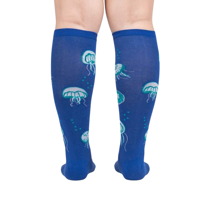 A pair of blue knee-high socks with a pattern of jellyfish.