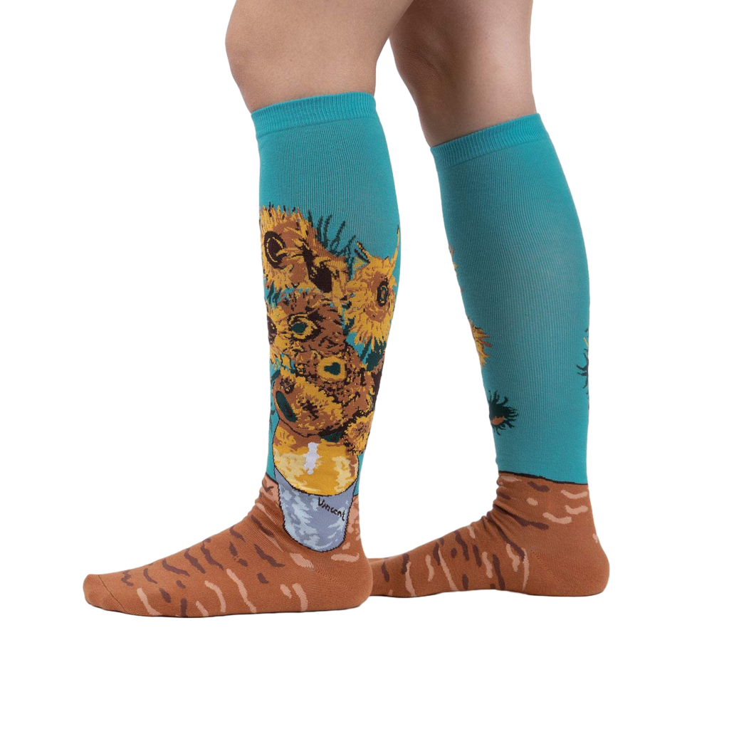 Lifestyle shot showing the socks on a person's legs.  The socks are teal with sunflowers.