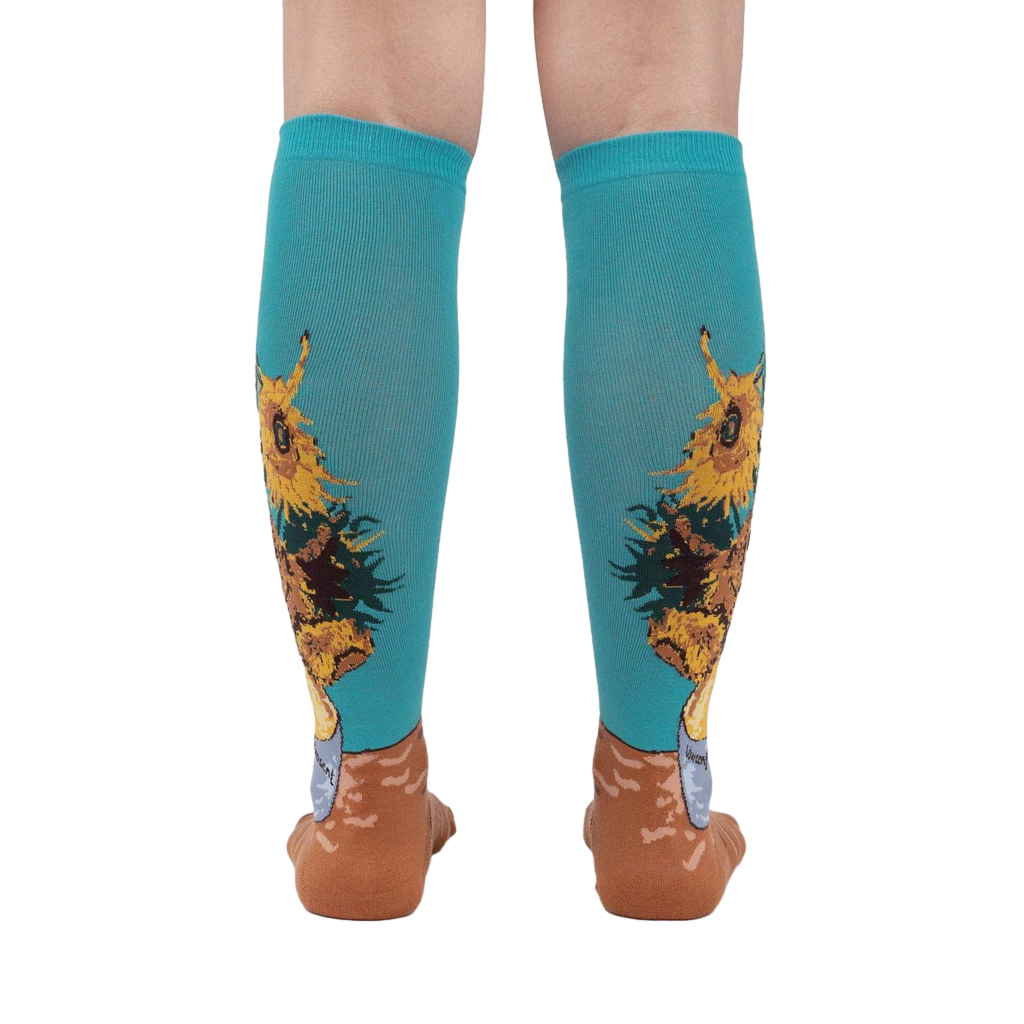 Rear view of the sunflower socks on a person's legs against a white background. The teal and sunflower design is clearly visible.