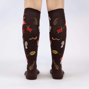 A pair of brown knee-high socks with a pattern of red mushrooms, green leaves, and orange snails.