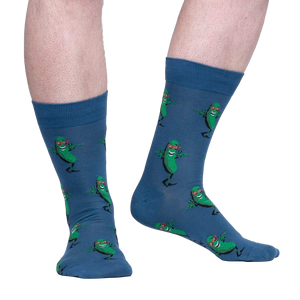 Lifestyle shot of model wearing a pair of blue crew socks with a fun pickle pattern.