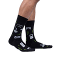 Lifestyle shot of a person's legs wearing the black 'Game On' socks, showcasing their fit and glow-in-the-dark feature.
