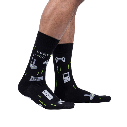 Lifestyle shot of a person's legs wearing the black 'Game On' socks, showcasing their fit and glow-in-the-dark feature.