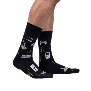 Lifestyle shot of a person's legs wearing the black 'Game On' socks, showcasing their fit and glow-in-the-dark feature.