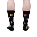 Rear view of a person's legs wearing the Puzzle Box socks, showcasing the full design on the back of the socks.