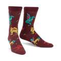 Burgundy crew socks featuring dragons, griffins, and phoenixes in teal, yellow, and red. Small triangles are scattered across the background.